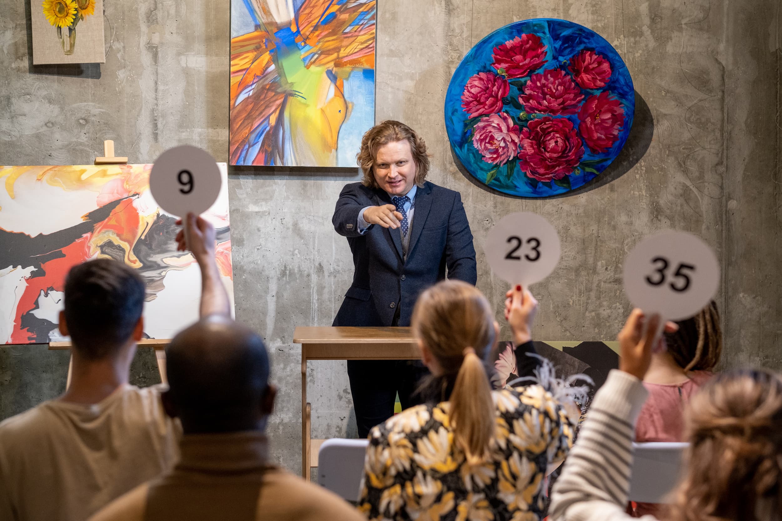 benefit auctioneer auctions off art at a live auction